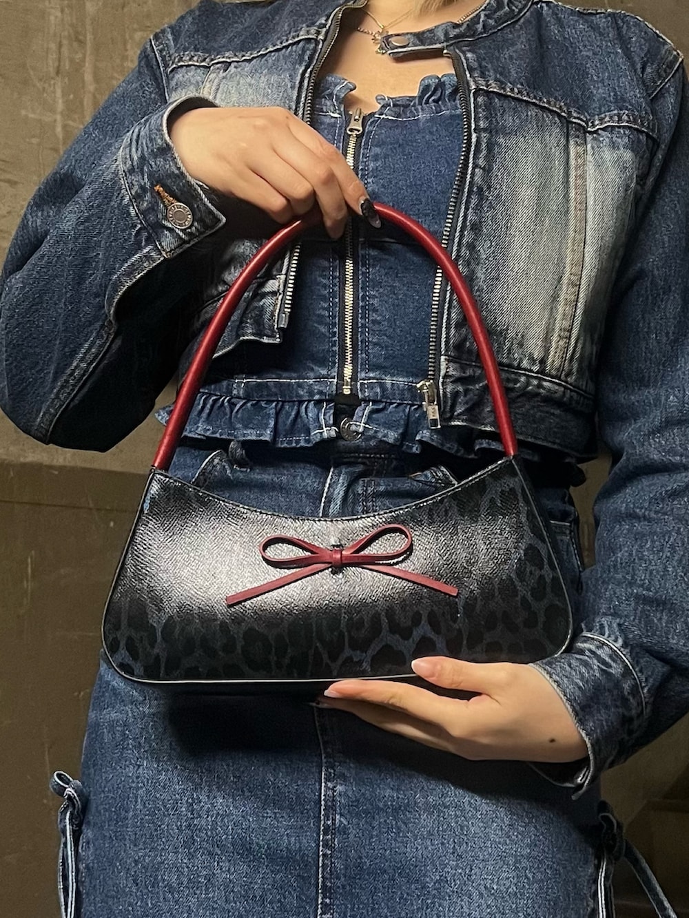 ブルー系のチューブトップ、ブルー系のハンドバッグ、ブルー系のデニムスカートを着用したレディースの春コーディネートの5枚目の写真