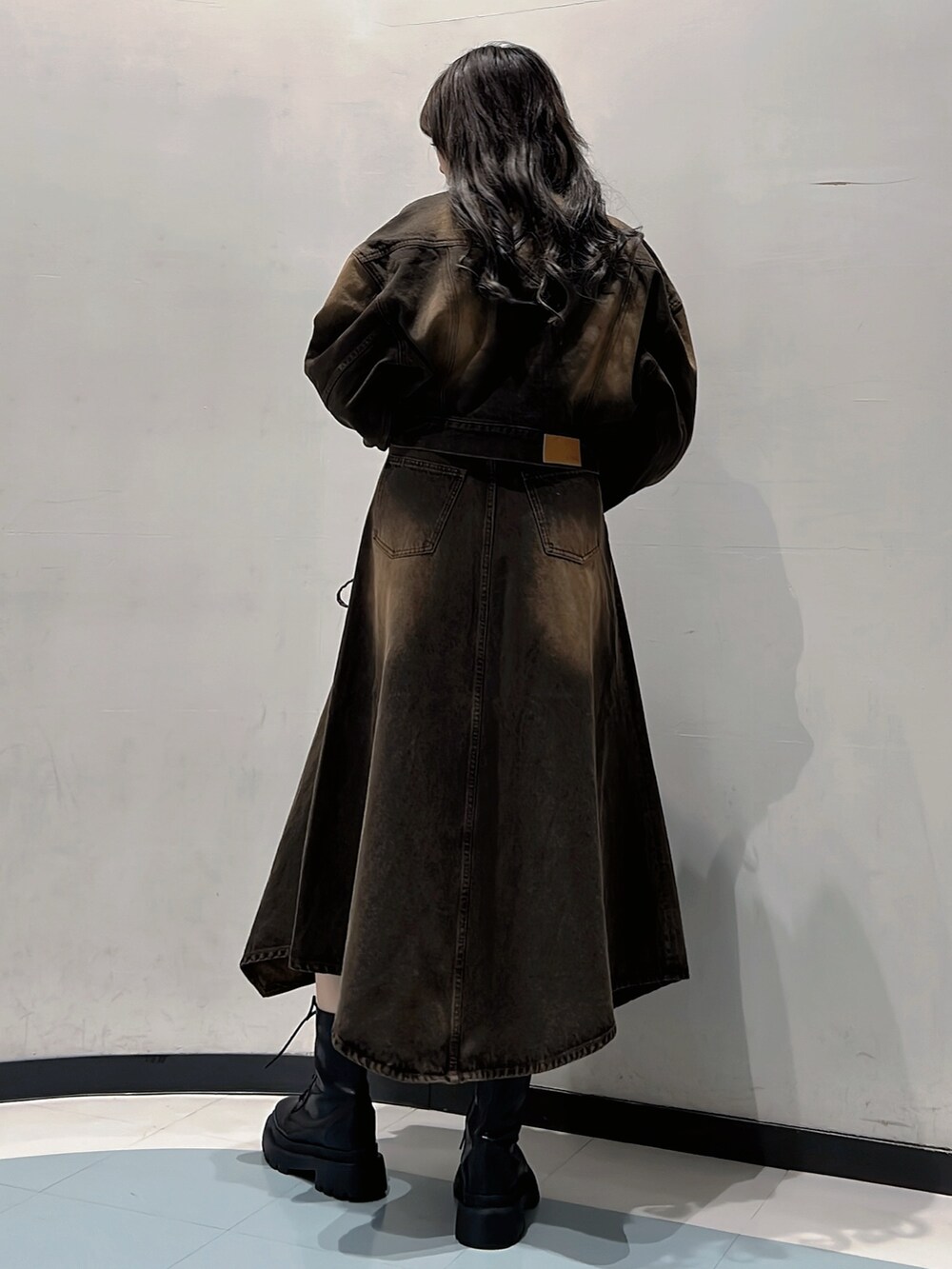 ブラウン系のデニムジャケット、ブラウン系のキャミソール、ブラウン系のデニムスカートを着用したレディースの秋コーディネートの3枚目の写真