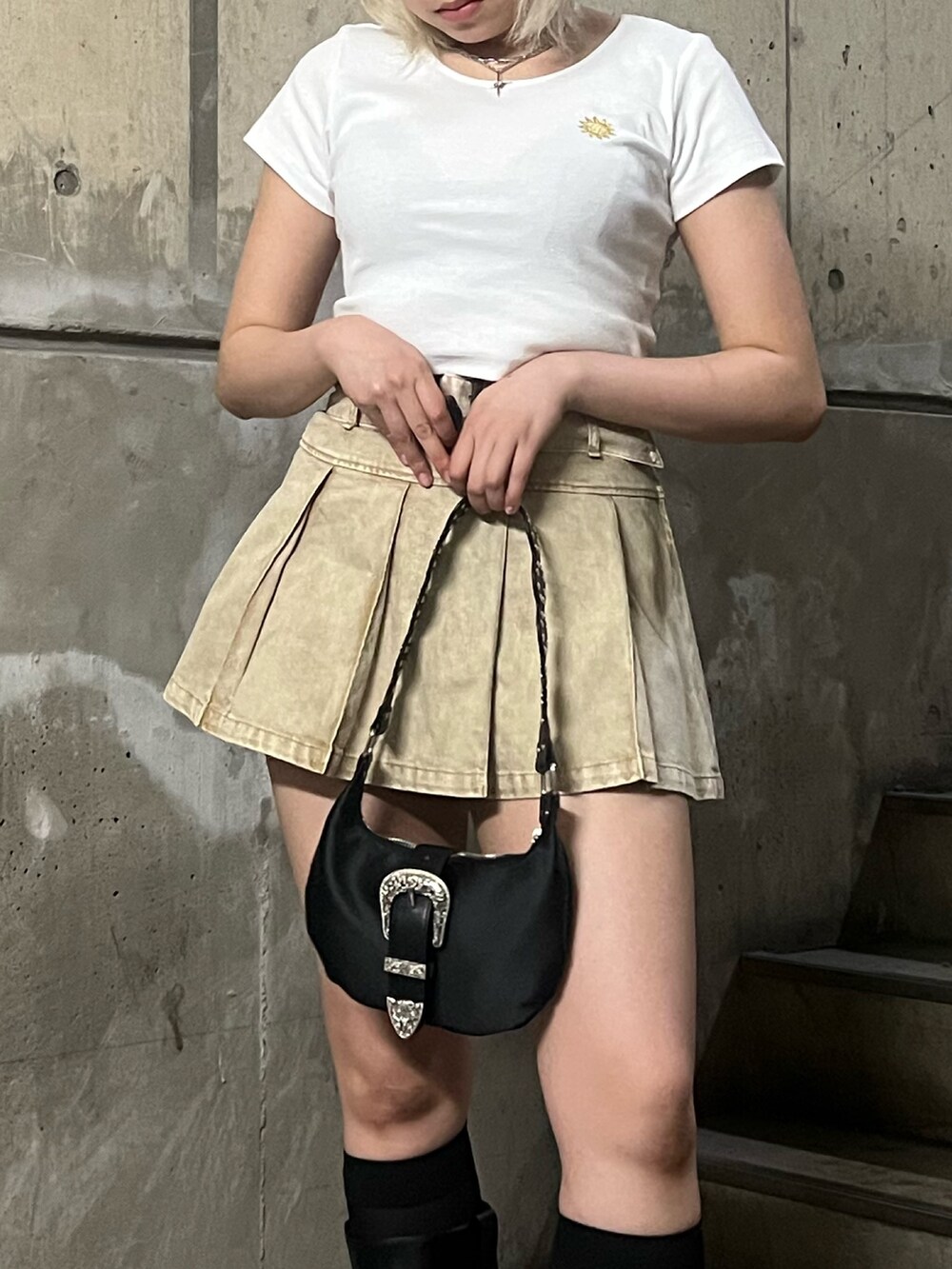 ホワイト系のTシャツ/カットソー、ベージュ系のスカート、ブラック系のショルダーバッグを着用したレディースの春コーディネートの4枚目の写真