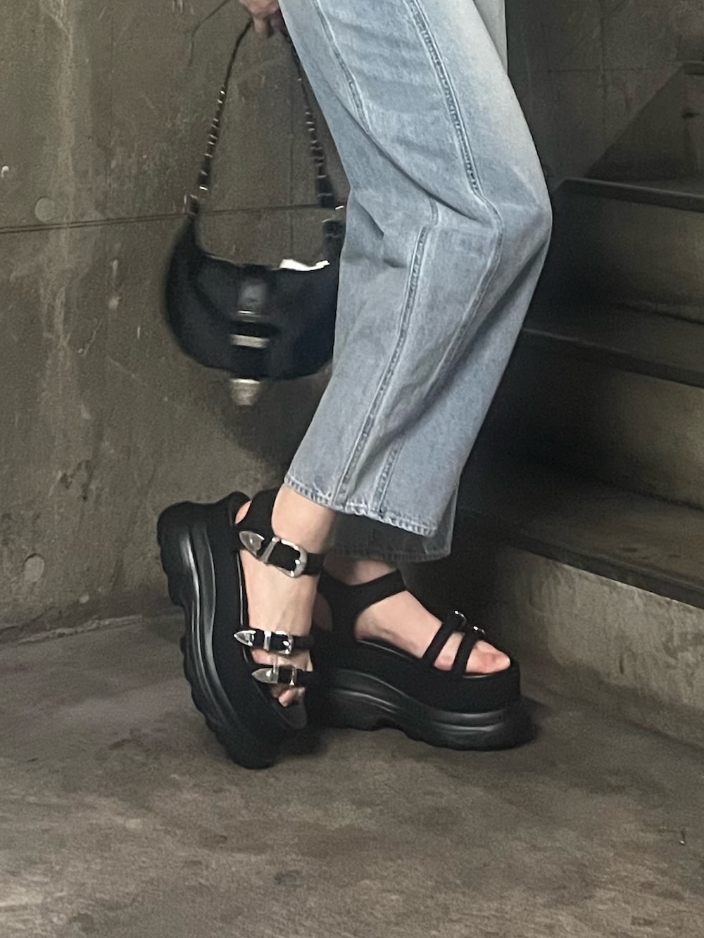 ブラック系のTシャツ/カットソー、ブルー系のデニムパンツ、ブラック系のショルダーバッグを着用したレディースの春コーディネートの6枚目の写真