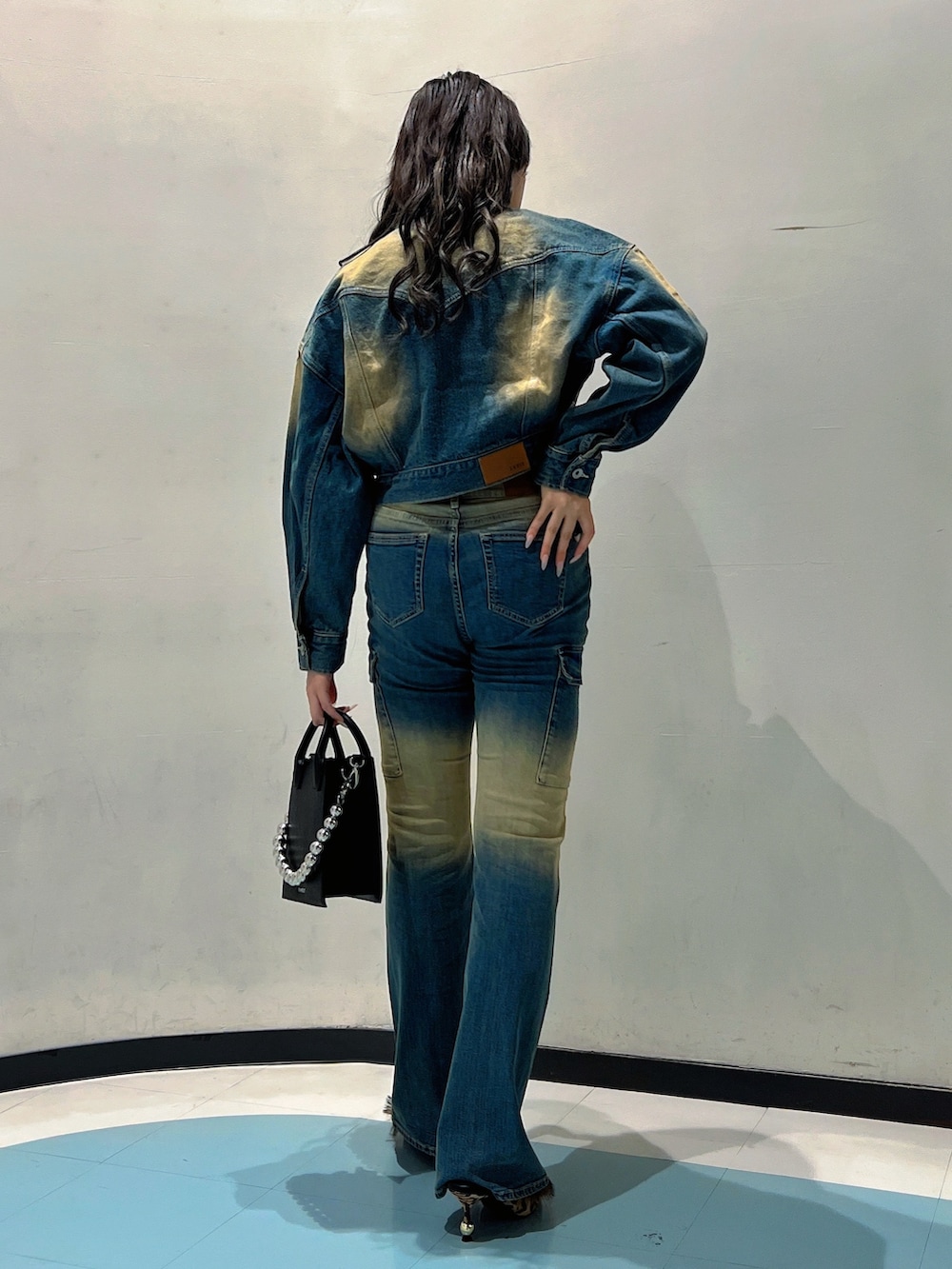 ブルー系のデニムジャケット、ホワイト系のTシャツ/カットソー、ブルー系のデニムパンツを着用したレディースの秋コーディネートの3枚目の写真