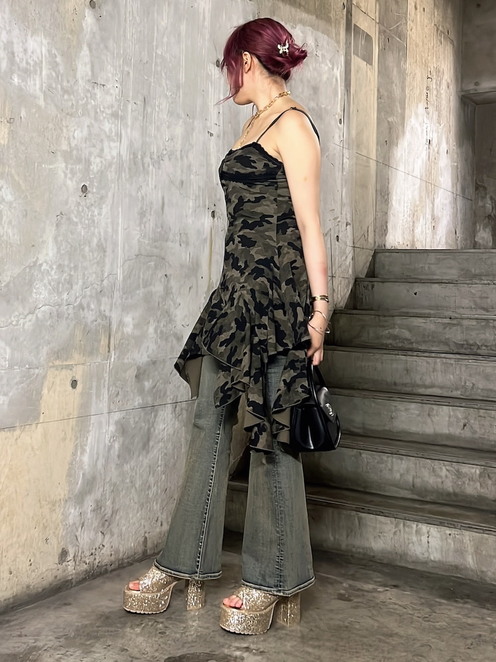 グリーン系のワンピース、ブラック系のハンドバッグ、ブルー系のデニムパンツを着用したレディースの夏コーディネートの2枚目の写真