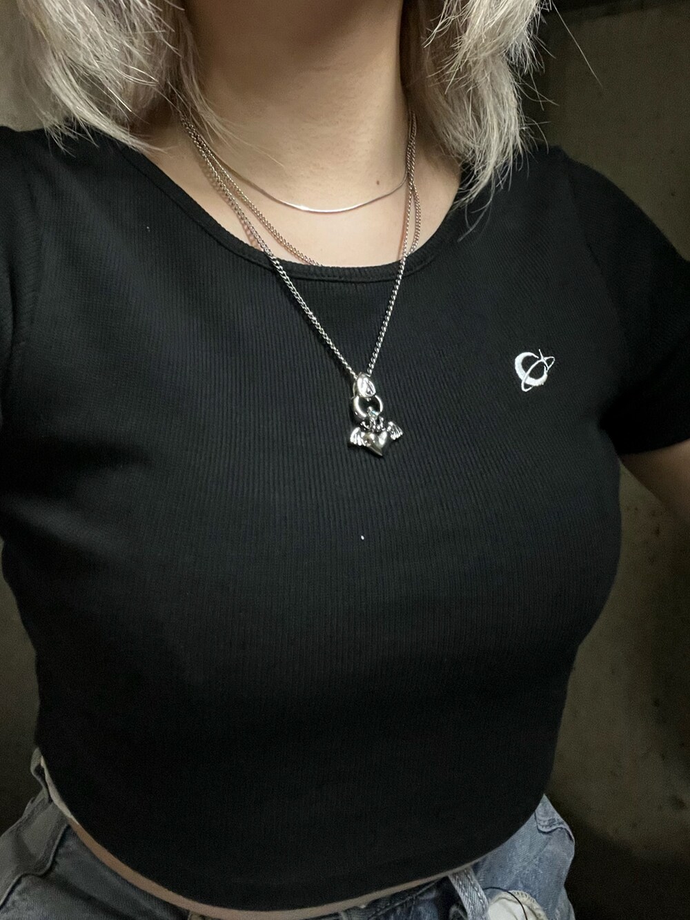 ブラック系のTシャツ/カットソー、ブルー系のデニムパンツ、ブラック系のショルダーバッグを着用したレディースの春コーディネートの4枚目の写真