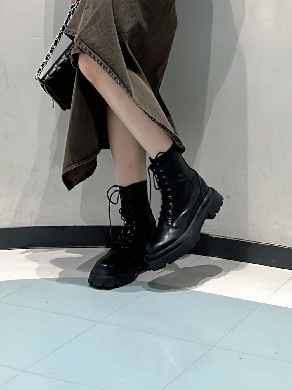 ブラウン系のキャミソール、ブラウン系のデニムスカート、ブラック系のハンドバッグを着用したレディースの秋コーディネートの6枚目の写真