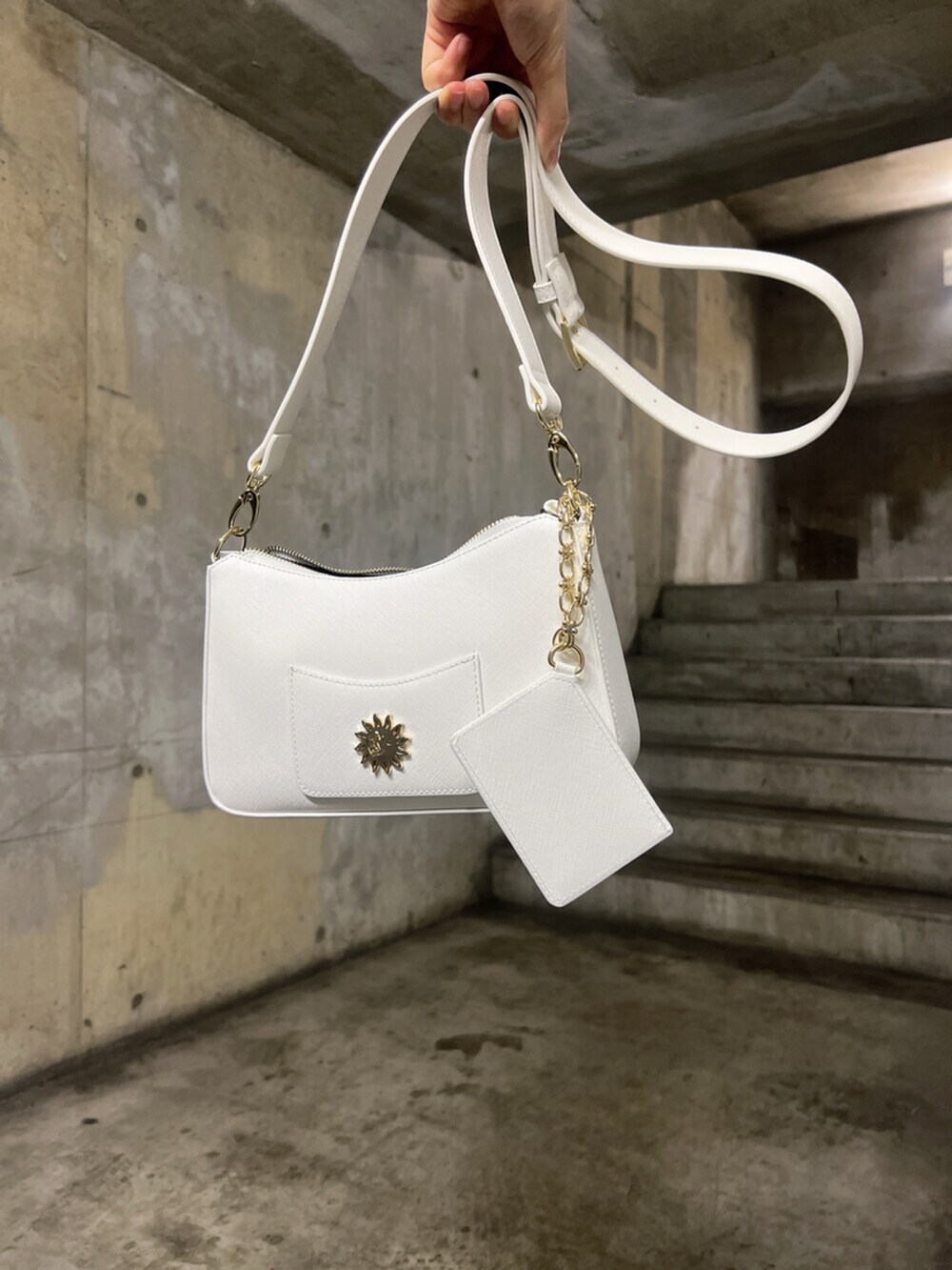 ブラック系のキャミソール、ホワイト系のショルダーバッグ、ブルー系のデニムパンツを着用したレディースの夏コーディネートの7枚目の写真