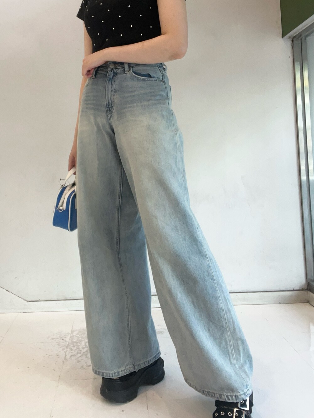 ブラック系のTシャツ/カットソー、ブルー系のショルダーバッグ、ブルー系のデニムパンツを着用したレディースの夏コーディネートの5枚目の写真