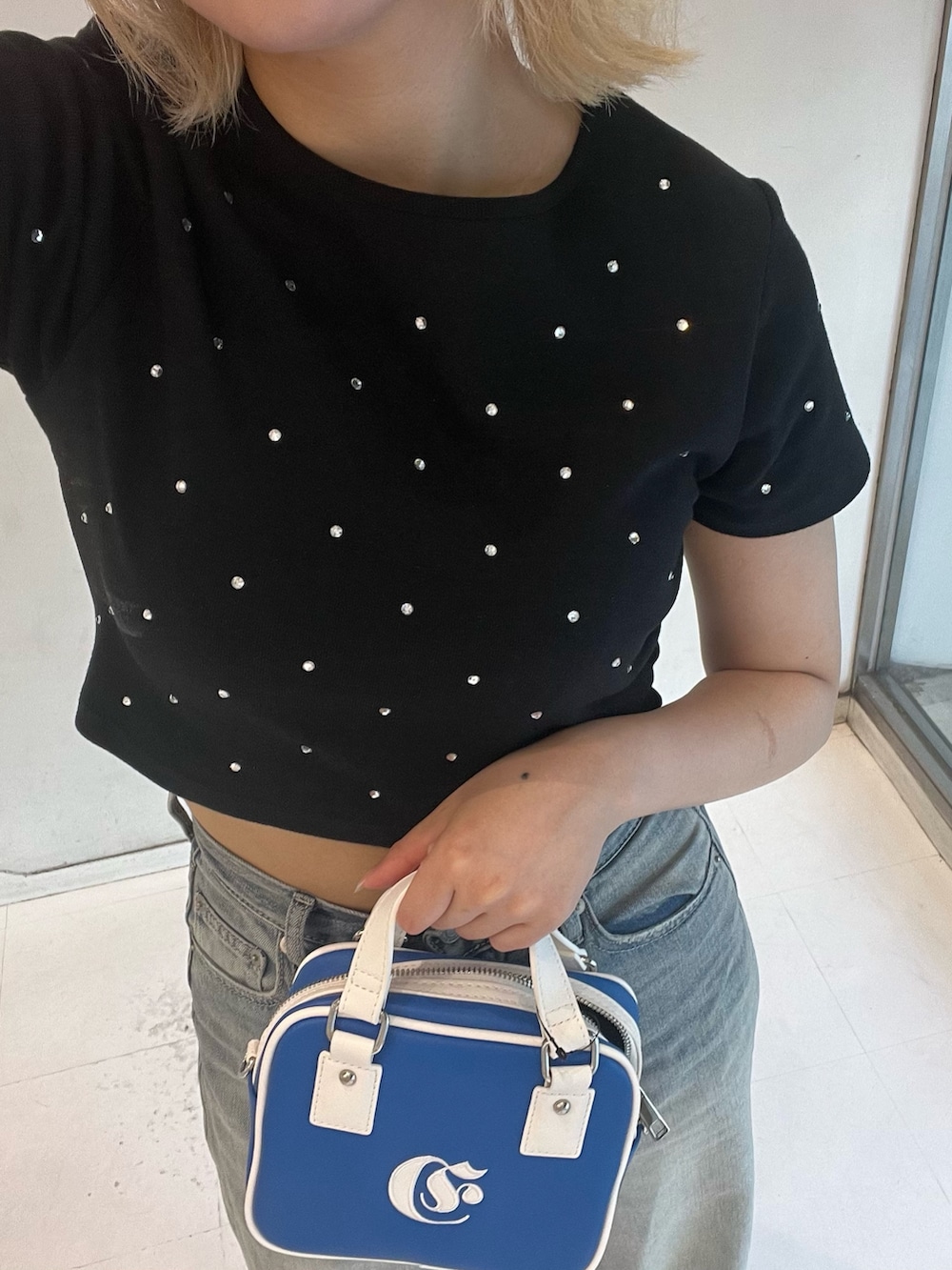 ブラック系のTシャツ/カットソー、ブルー系のショルダーバッグ、ブルー系のデニムパンツを着用したレディースの夏コーディネートの4枚目の写真