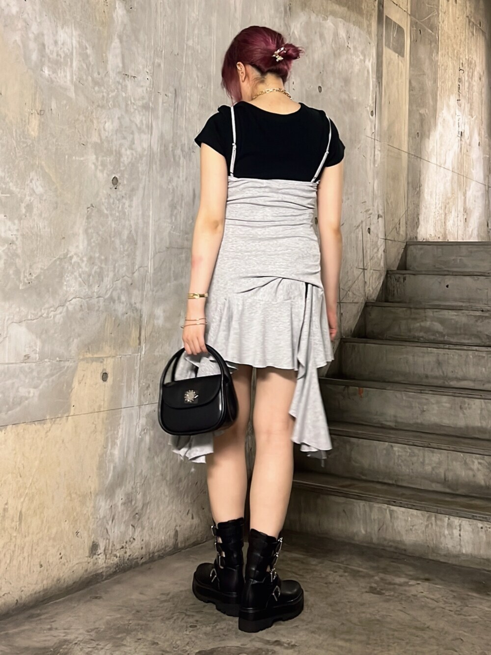 ブラック系のブーツ、ブラック系のTシャツ/カットソー、ブラック系のハンドバッグを着用したレディースの夏コーディネートの3枚目の写真