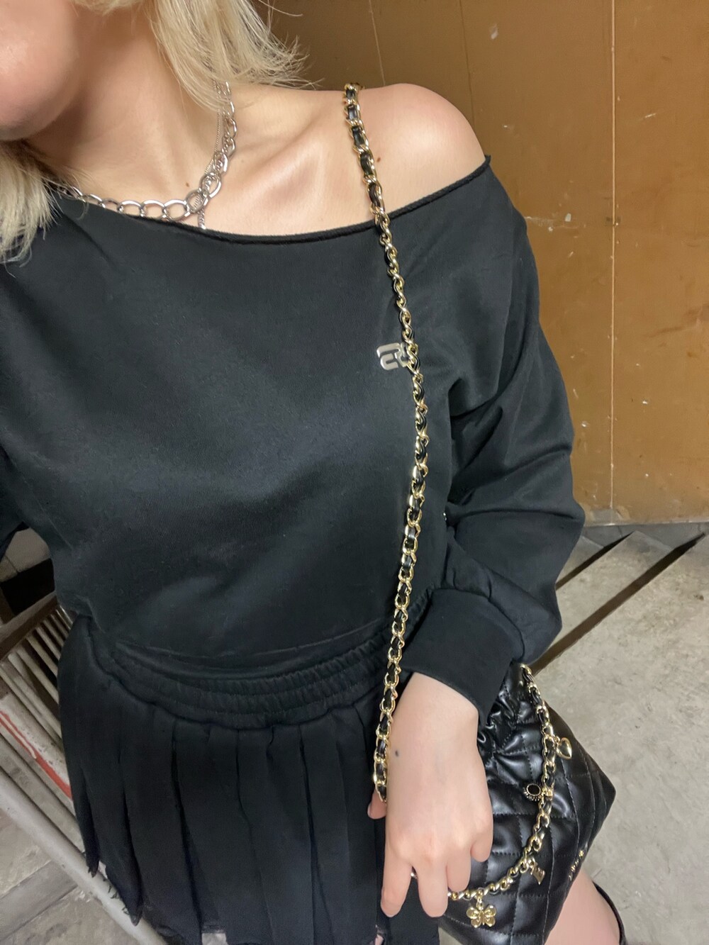 ブラック系のスウェット、ブラック系のショルダーバッグ、ブラック系のスカートを着用したレディースの春コーディネートの5枚目の写真