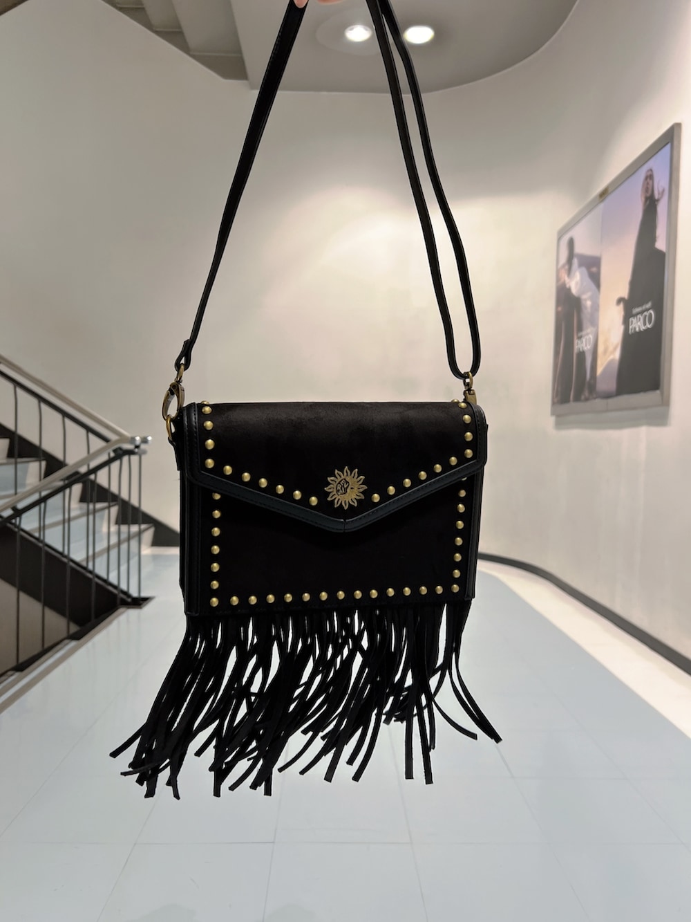 ブルー系のニット/セーター、ブルー系のデニムパンツ、ブラック系のショルダーバッグを着用したレディースの秋コーディネートの7枚目の写真