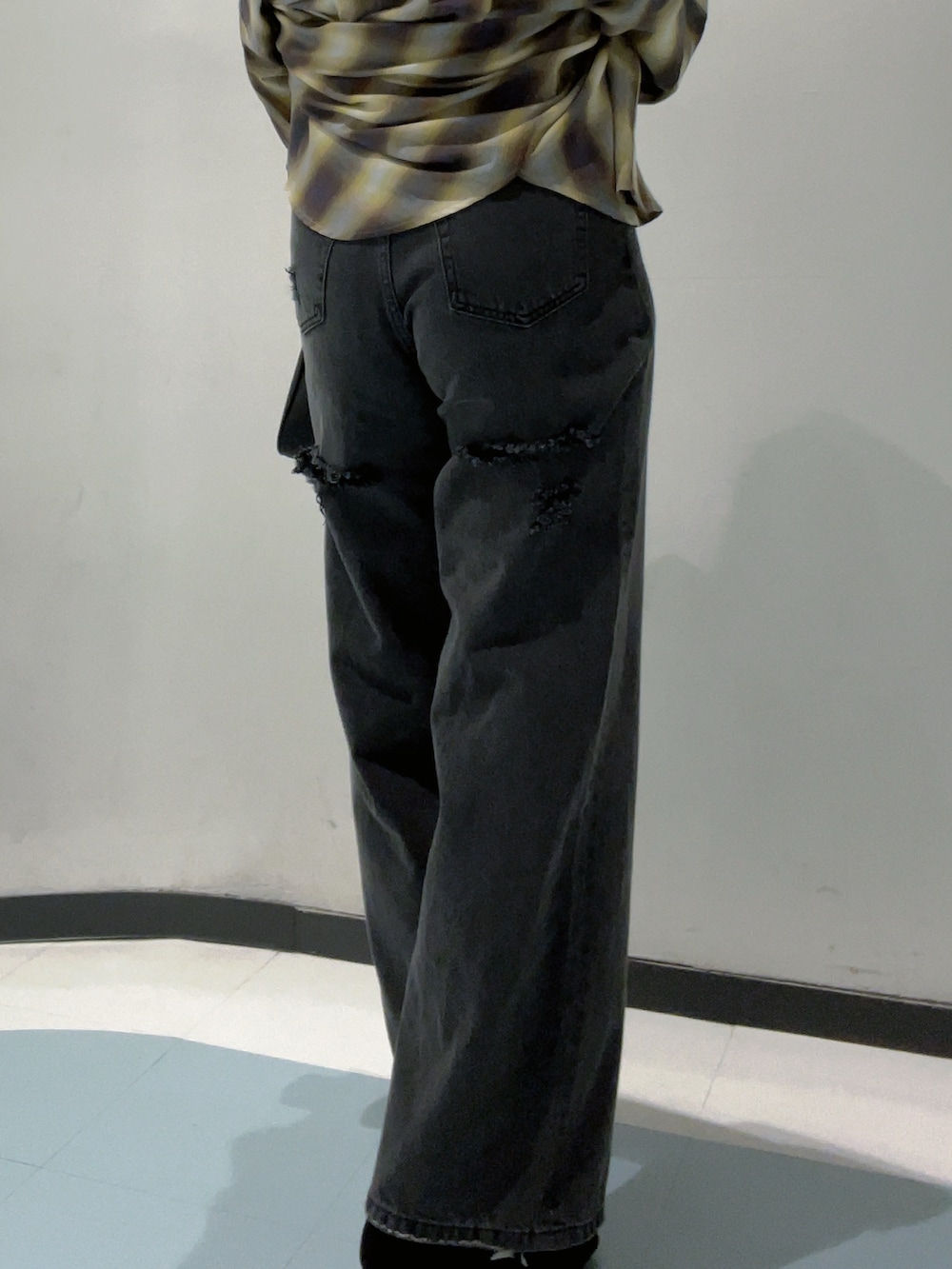 ブラック系のワンピース、イエロー系のシャツ/ブラウス、ブラック系のデニムパンツを着用したレディースの秋コーディネートの4枚目の写真