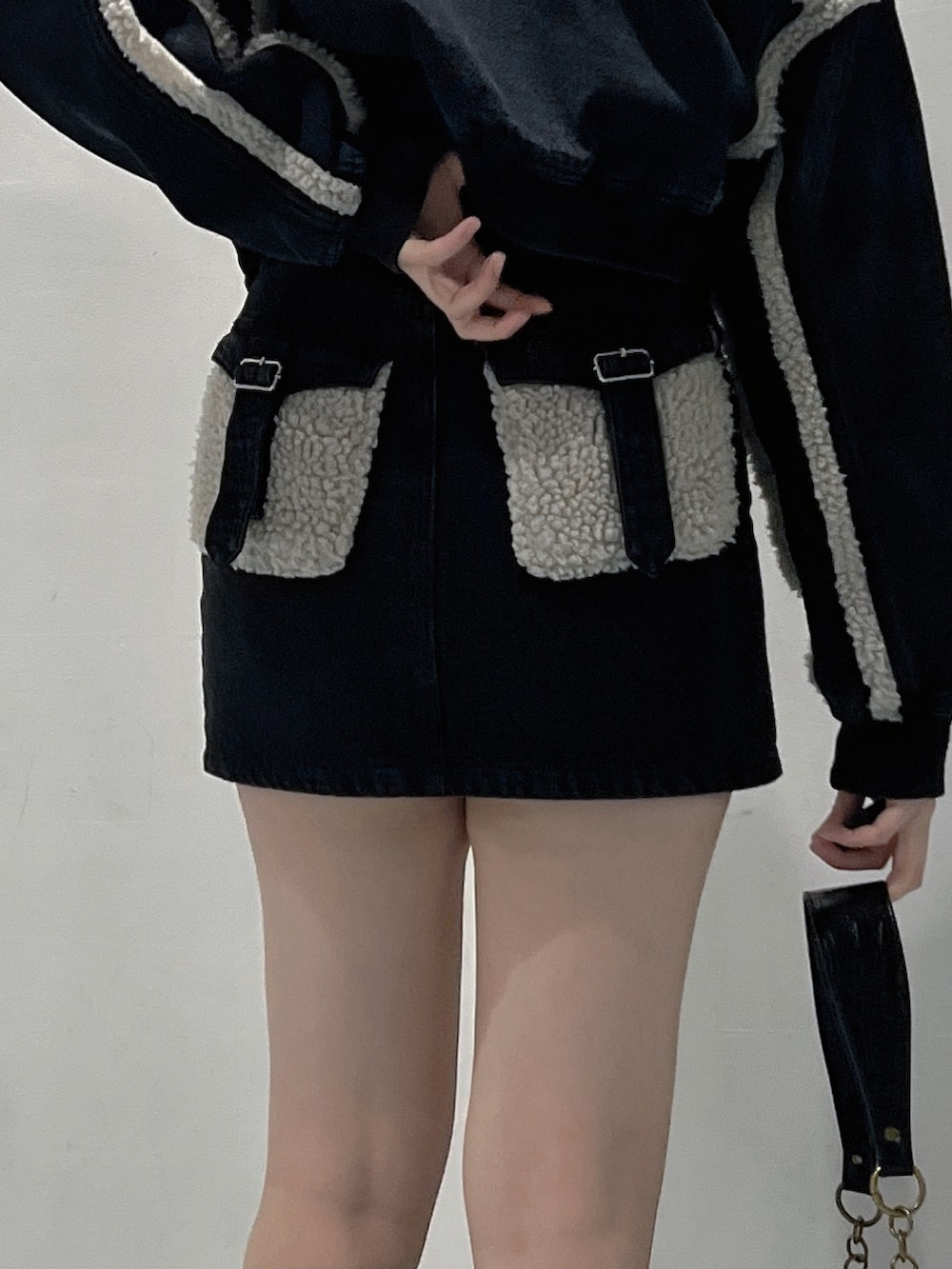 ブラック系のブルゾン、ブラック系のTシャツ/カットソー、ブラック系のデニムスカートを着用したレディースの秋コーディネートの6枚目の写真