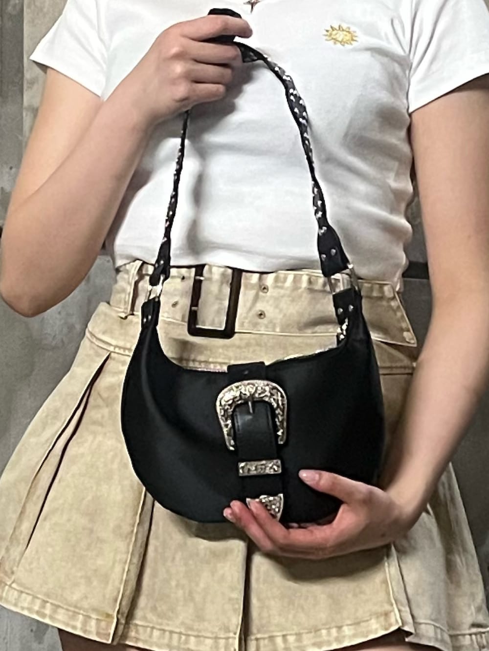 ホワイト系のTシャツ/カットソー、ベージュ系のスカート、ブラック系のショルダーバッグを着用したレディースの春コーディネートの6枚目の写真