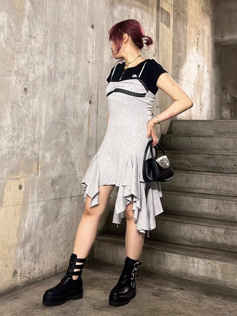 ブラック系のブーツ、ブラック系のTシャツ/カットソー、ブラック系のハンドバッグを着用したレディースの夏コーディネートの2枚目の写真