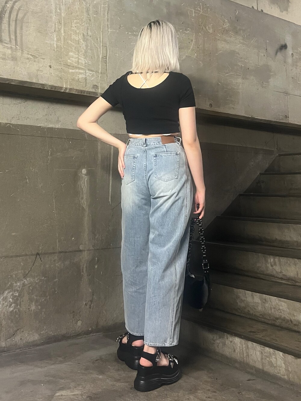 ブラック系のTシャツ/カットソー、ブルー系のデニムパンツ、ブラック系のショルダーバッグを着用したレディースの春コーディネートの3枚目の写真