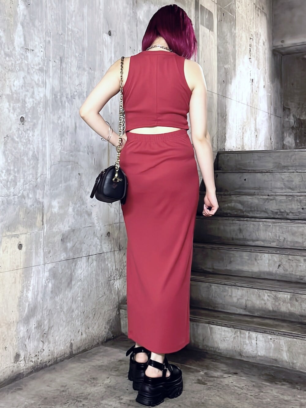 ブラック系のショルダーバッグ、ブラック系のサンダル、レッド系のワンピースを着用したレディースの夏コーディネートの3枚目の写真