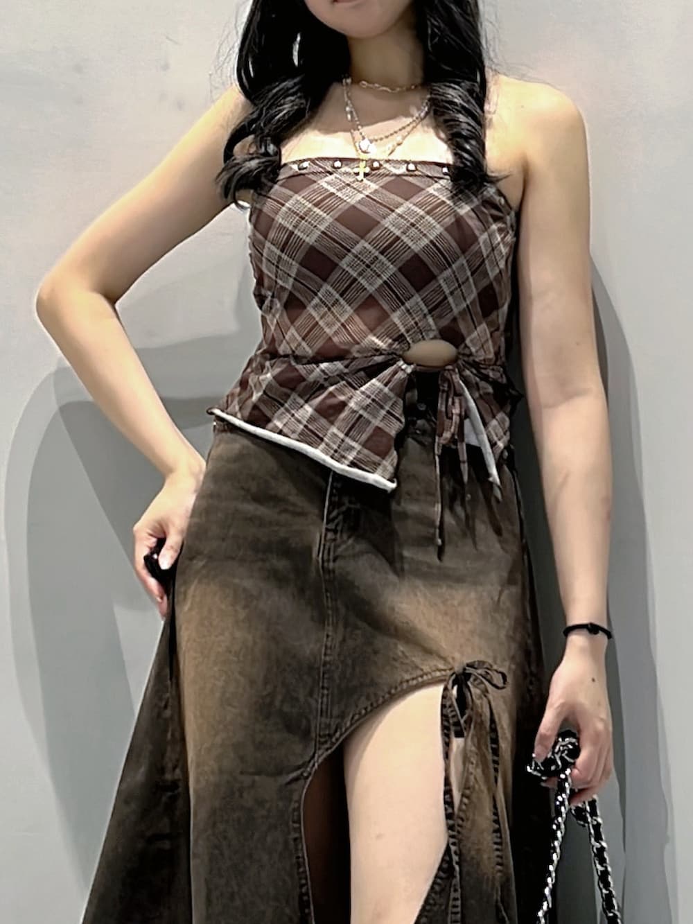 ブラウン系のキャミソール、ブラウン系のデニムスカート、ブラック系のハンドバッグを着用したレディースの秋コーディネートの4枚目の写真