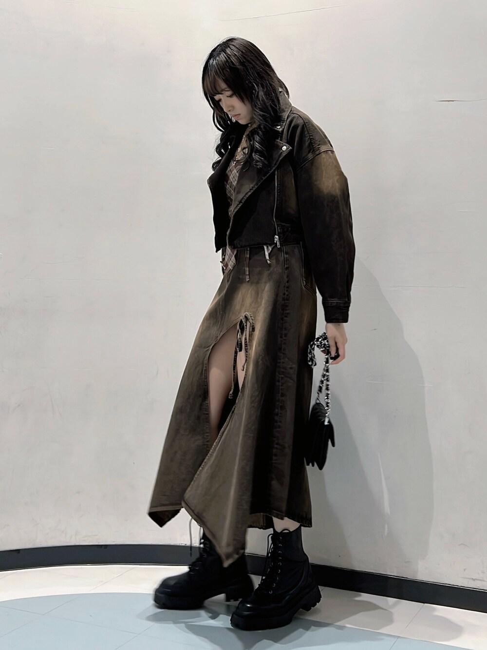 ブラウン系のデニムジャケット、ブラウン系のキャミソール、ブラウン系のデニムスカートを着用したレディースの秋コーディネートの2枚目の写真