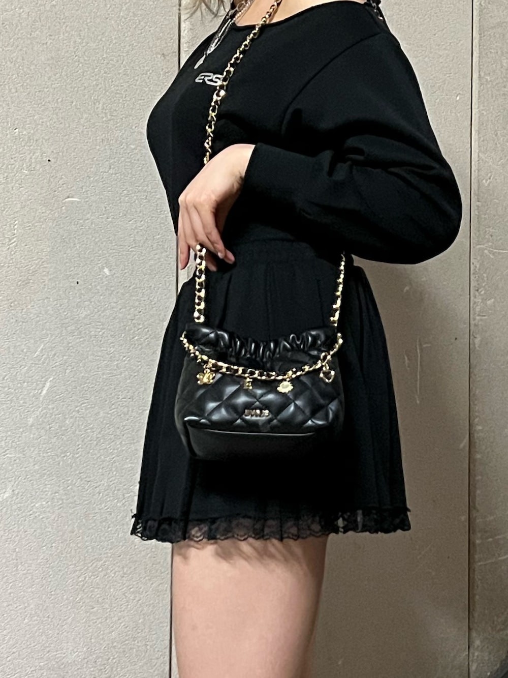 ブラック系のスウェット、ブラック系のショルダーバッグ、ブラック系のスカートを着用したレディースの春コーディネートの7枚目の写真