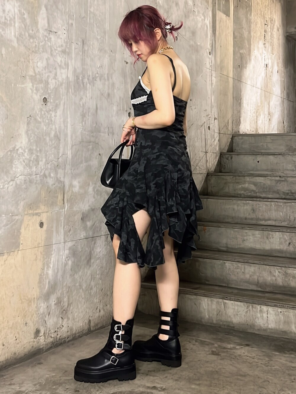 ブラック系のワンピース、ブラック系のブーツ、ブラック系のハンドバッグを着用したレディースの夏コーディネートの3枚目の写真