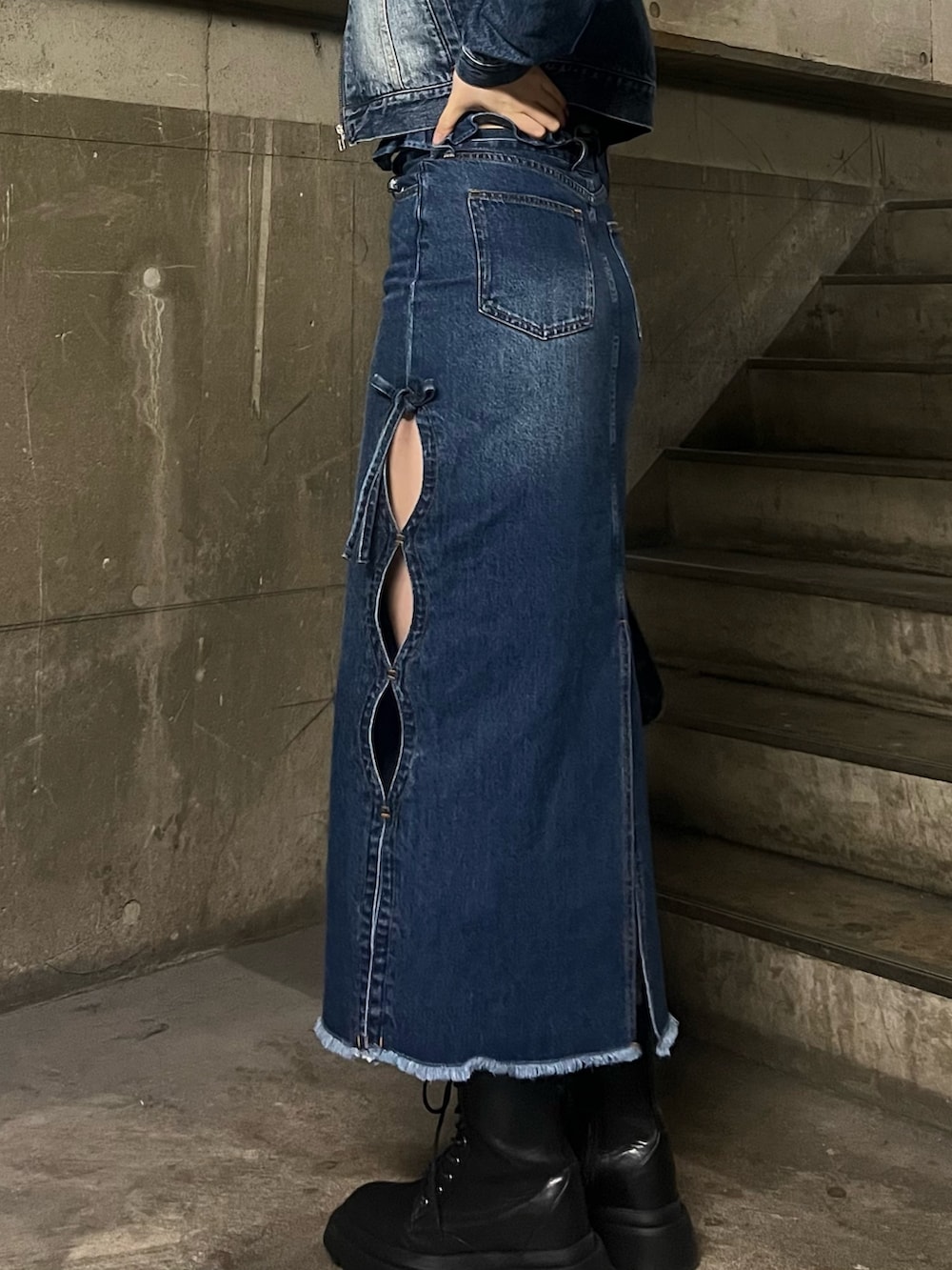 ブルー系のチューブトップ、ブルー系のハンドバッグ、ブルー系のデニムスカートを着用したレディースの春コーディネートの4枚目の写真