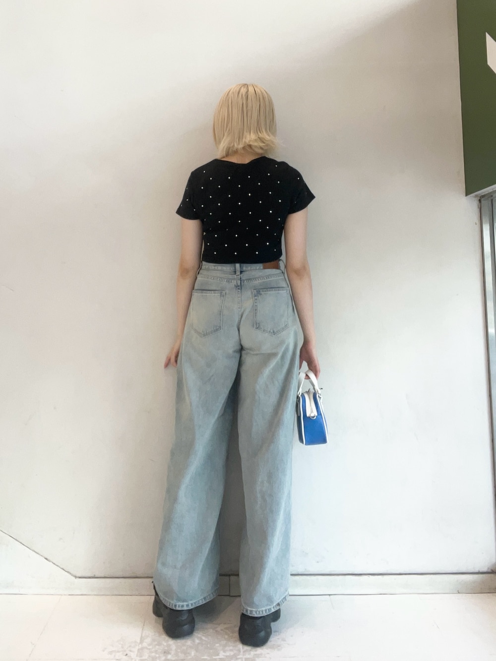 ブラック系のTシャツ/カットソー、ブルー系のショルダーバッグ、ブルー系のデニムパンツを着用したレディースの夏コーディネートの3枚目の写真