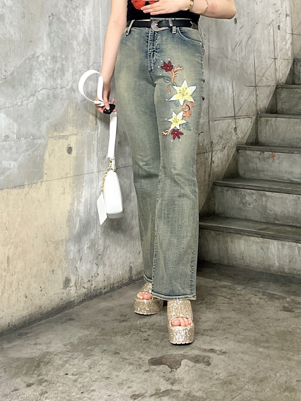 ブラック系のキャミソール、ホワイト系のショルダーバッグ、ブルー系のデニムパンツを着用したレディースの夏コーディネートの5枚目の写真