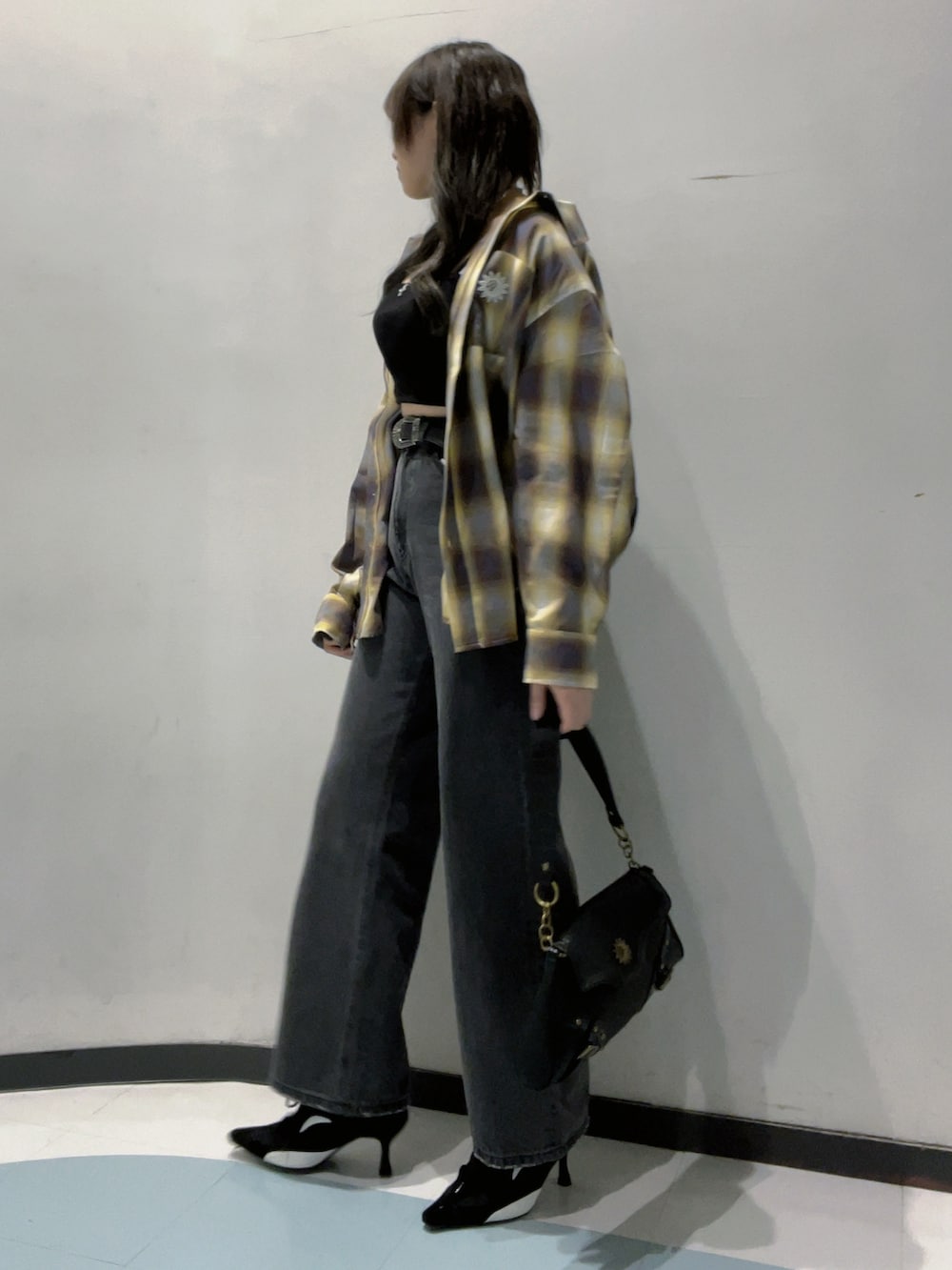 ブラック系のワンピース、イエロー系のシャツ/ブラウス、ブラック系のデニムパンツを着用したレディースの秋コーディネートの2枚目の写真