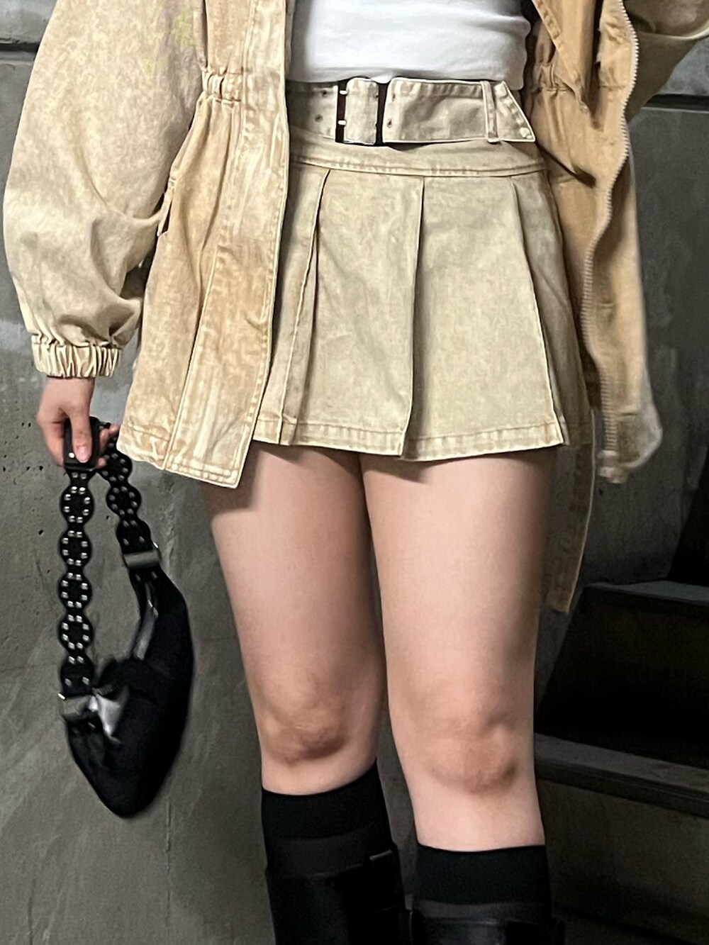 ホワイト系のTシャツ/カットソー、ベージュ系のスカート、ブラック系のショルダーバッグを着用したレディースの春コーディネートの5枚目の写真