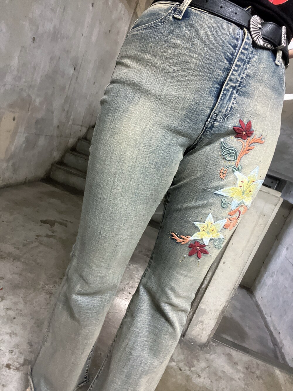 グリーン系のワンピース、ブラック系のハンドバッグ、ブルー系のデニムパンツを着用したレディースの夏コーディネートの5枚目の写真