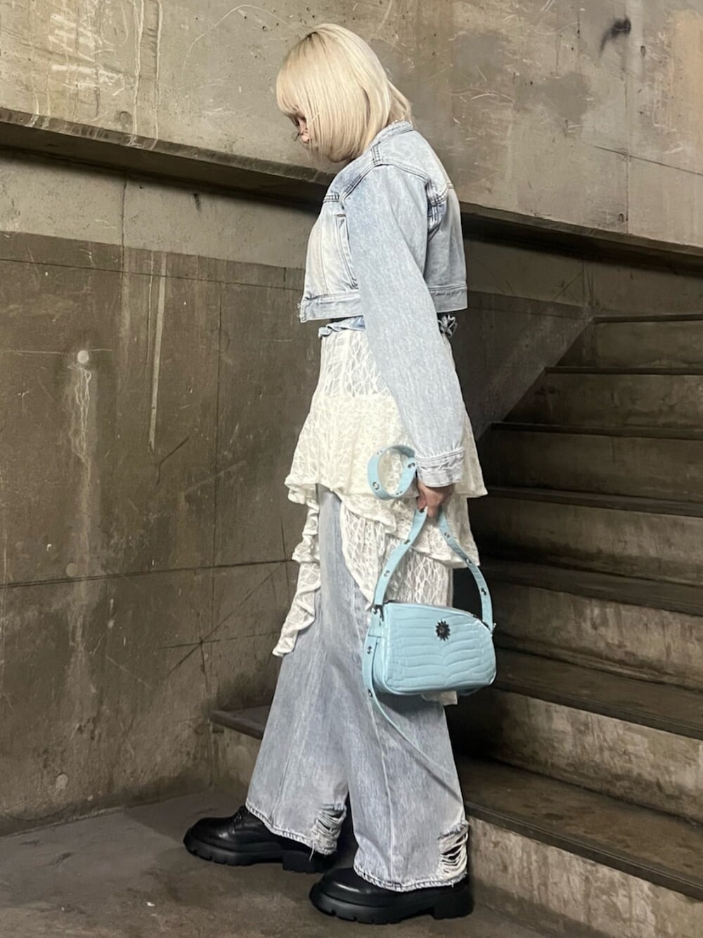 ブラック系のブーツ、ホワイト系のスカート、ブルー系のデニムジャケットを着用したレディースの冬コーディネートの2枚目の写真