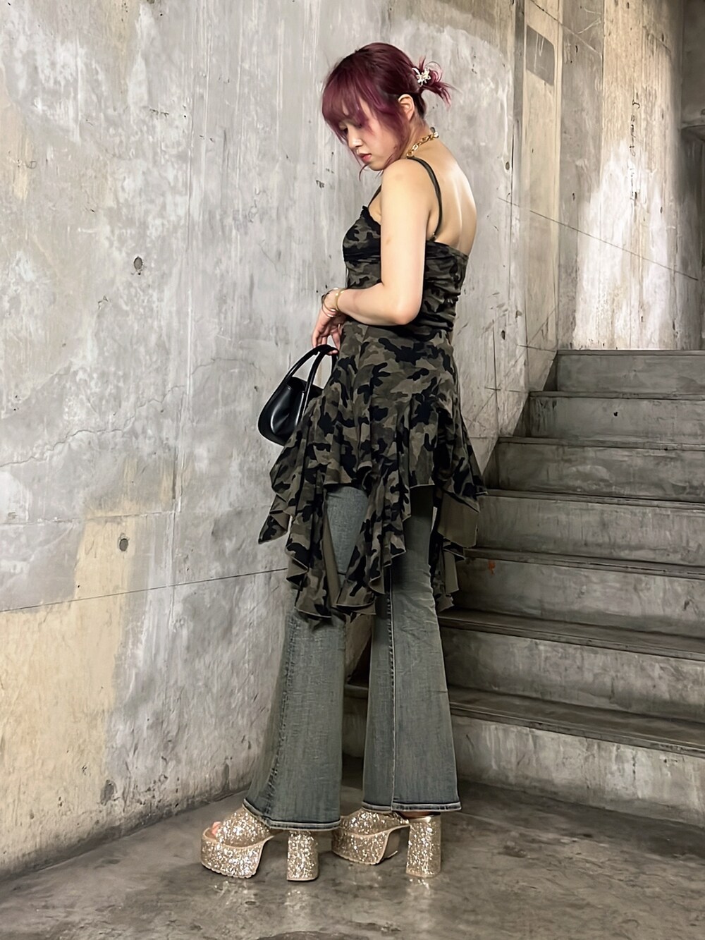 グリーン系のワンピース、ブラック系のハンドバッグ、ブルー系のデニムパンツを着用したレディースの夏コーディネートの3枚目の写真