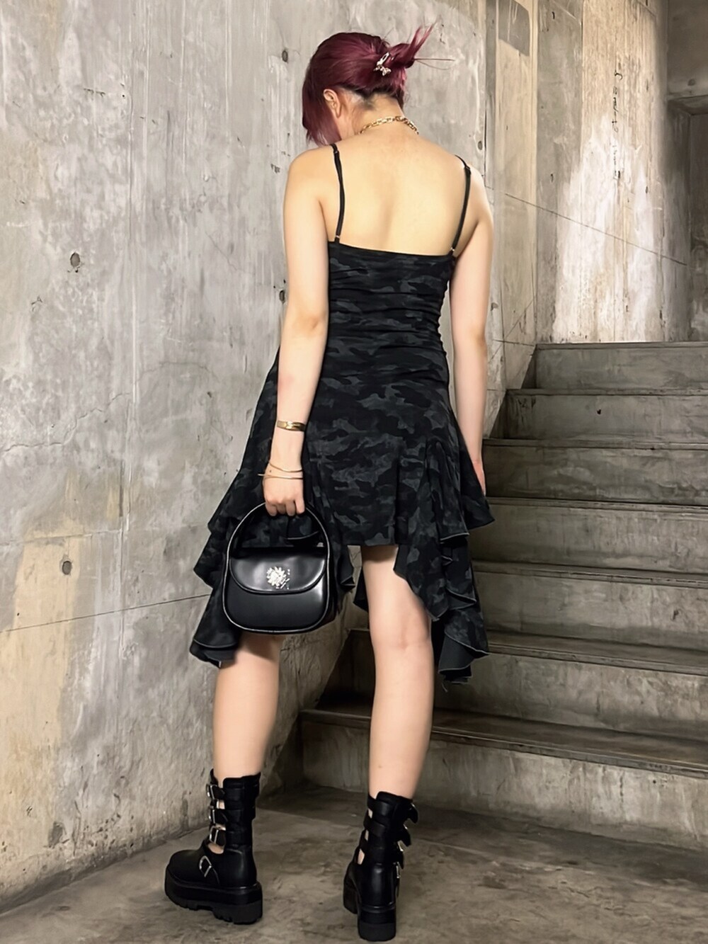 ブラック系のワンピース、ブラック系のブーツ、ブラック系のハンドバッグを着用したレディースの夏コーディネートの2枚目の写真