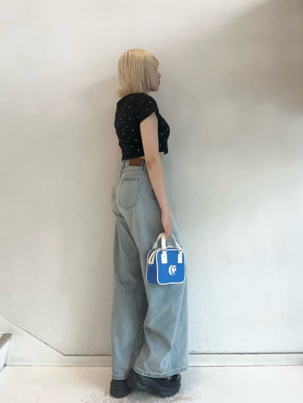 ブラック系のTシャツ/カットソー、ブルー系のショルダーバッグ、ブルー系のデニムパンツを着用したレディースの夏コーディネートの2枚目の写真
