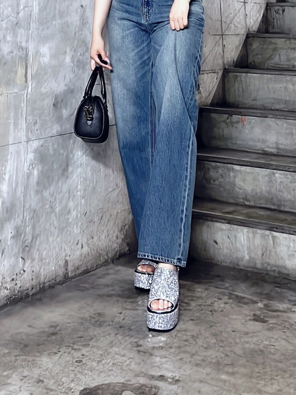 ブラック系のショルダーバッグ、シルバー系のサンダル、ブルー系のデニムパンツを着用したレディースの夏コーディネートの6枚目の写真