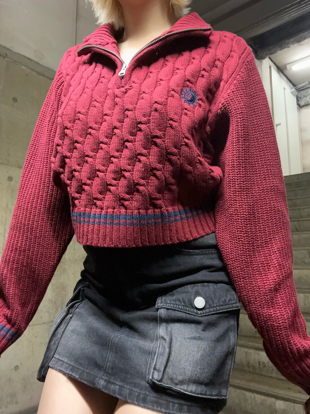 レッド系のニット/セーター、ピンク系のショルダーバッグ、ブラック系のデニムスカートを着用したレディースの秋コーディネートの4枚目の写真