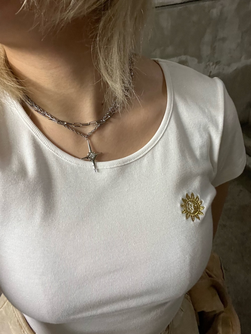 ホワイト系のTシャツ/カットソー、ベージュ系のスカート、ブラック系のショルダーバッグを着用したレディースの春コーディネートの8枚目の写真