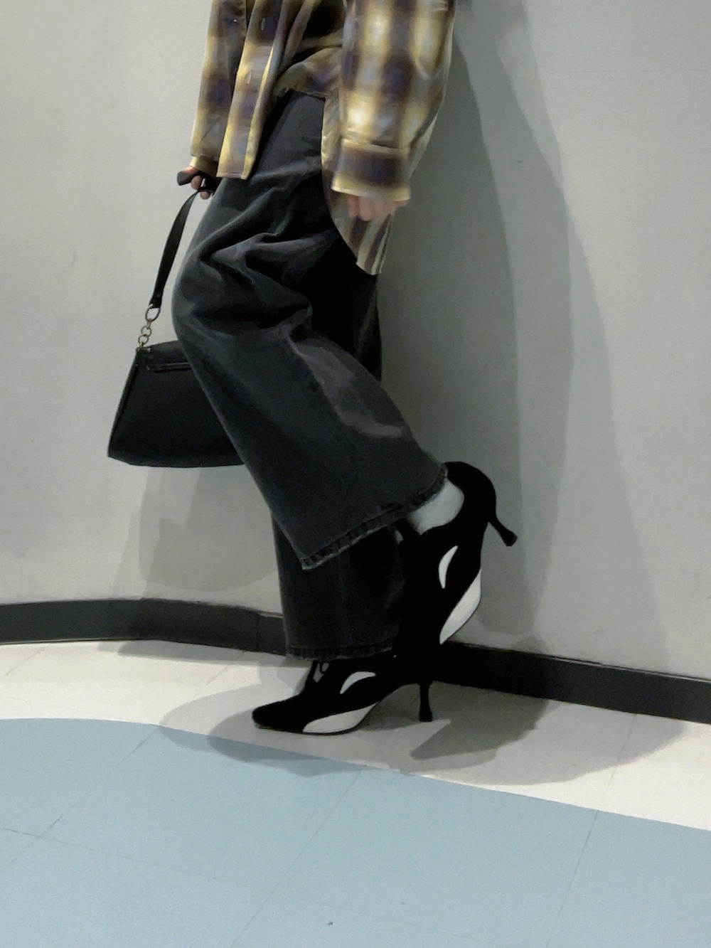 ブラック系のワンピース、イエロー系のシャツ/ブラウス、ブラック系のデニムパンツを着用したレディースの秋コーディネートの7枚目の写真