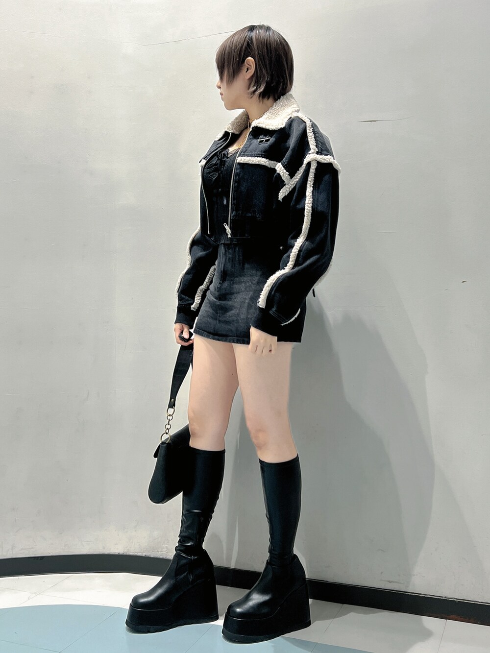 ブラック系のブルゾン、ブラック系のTシャツ/カットソー、ブラック系のデニムスカートを着用したレディースの秋コーディネートの2枚目の写真