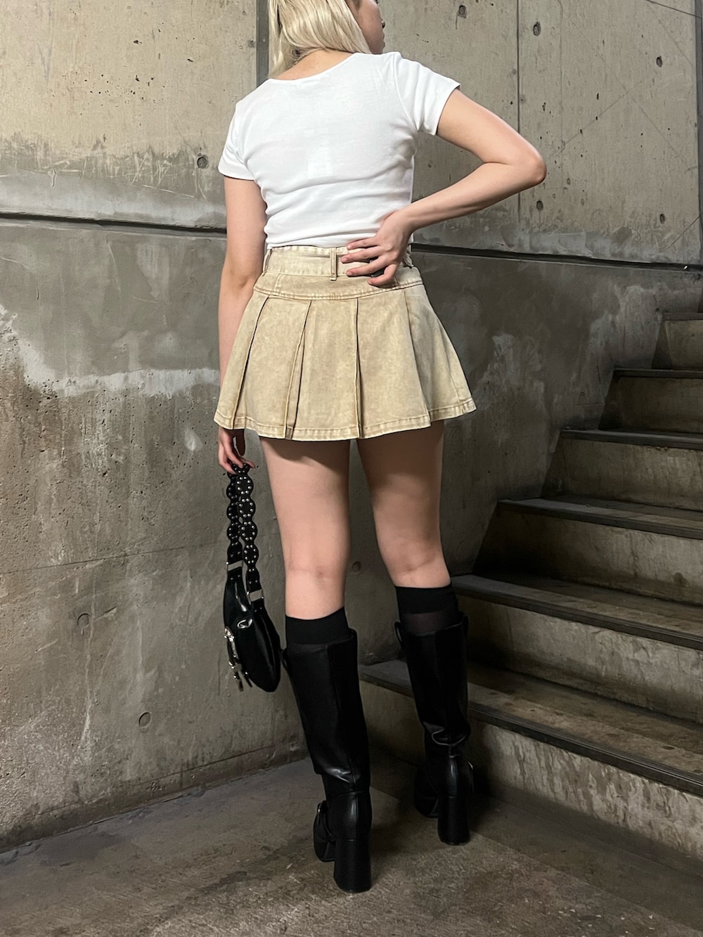 ホワイト系のTシャツ/カットソー、ベージュ系のスカート、ブラック系のショルダーバッグを着用したレディースの春コーディネートの3枚目の写真