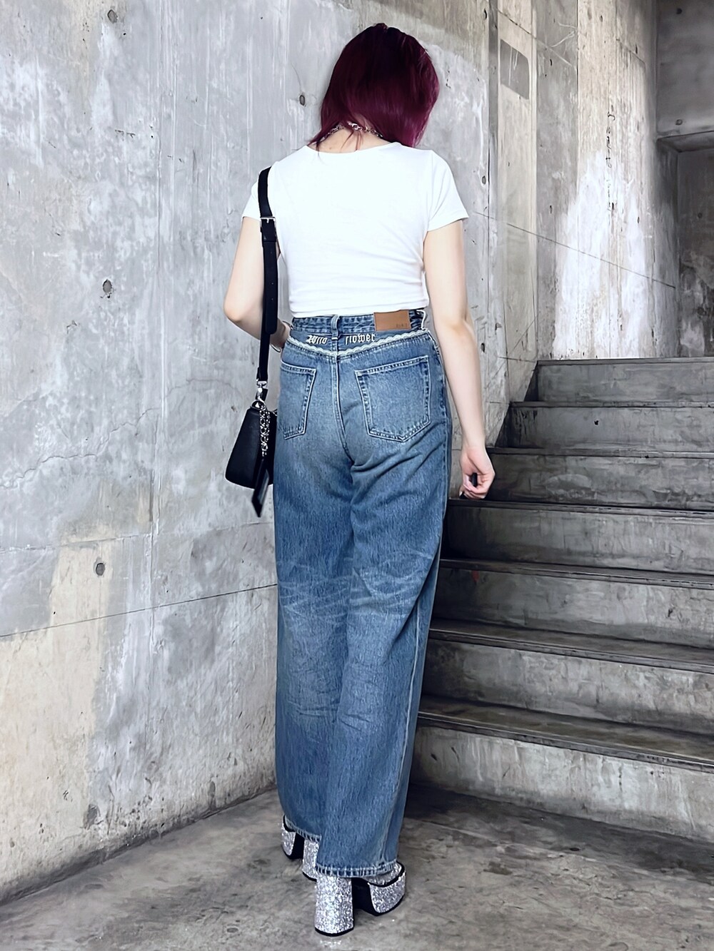 ホワイト系のTシャツ/カットソー、ブラック系のショルダーバッグ、ブルー系のデニムパンツを着用したレディースの夏コーディネートの3枚目の写真