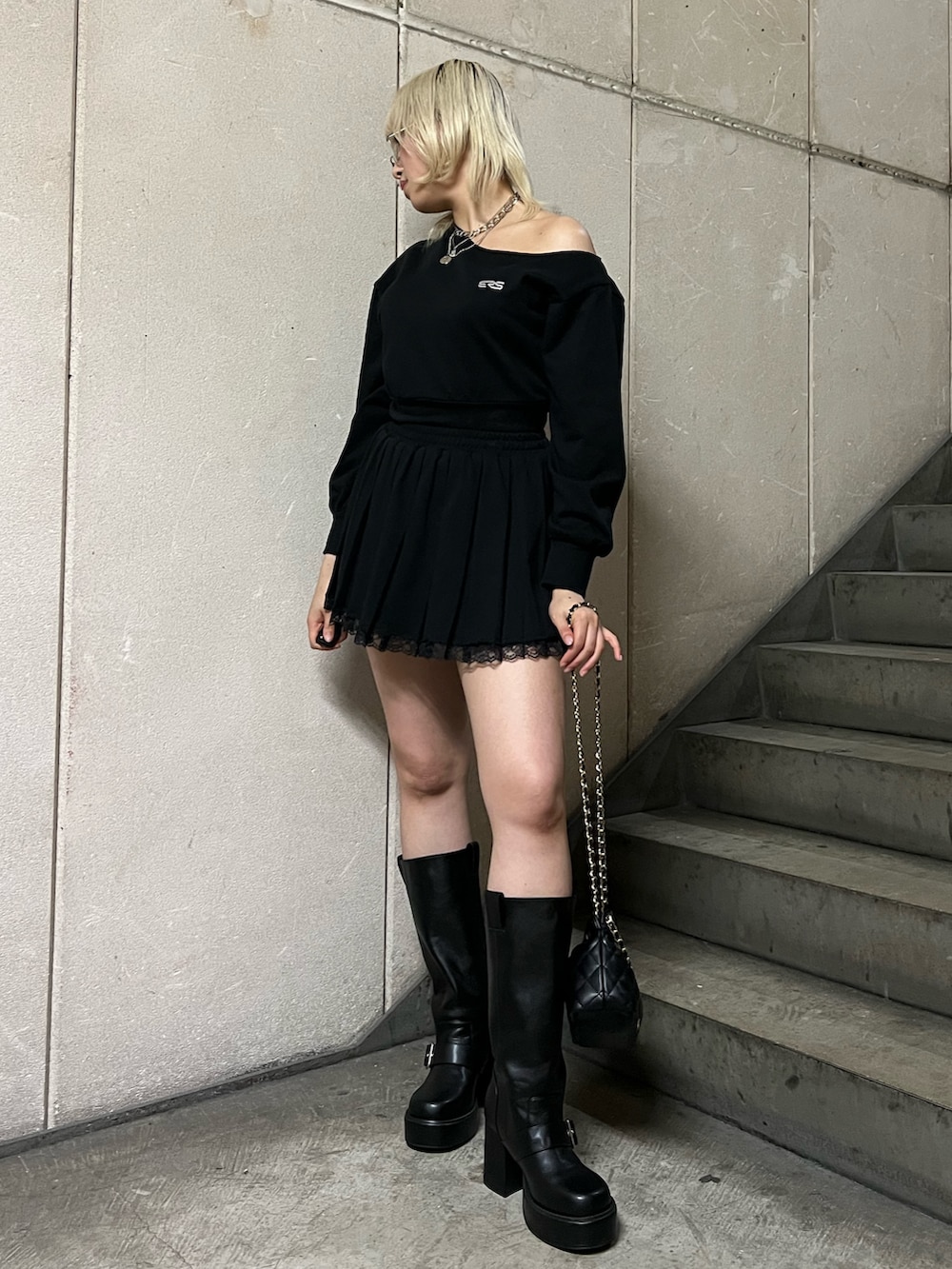 ブラック系のスウェット、ブラック系のショルダーバッグ、ブラック系のスカートを着用したレディースの春コーディネートの4枚目の写真