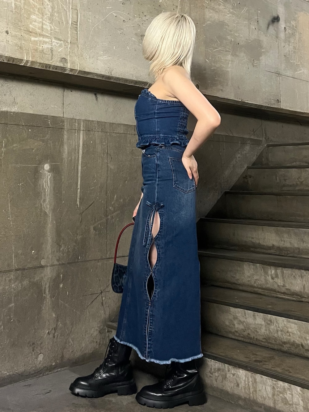 ブルー系のチューブトップ、ブルー系のハンドバッグ、ブルー系のデニムスカートを着用したレディースの春コーディネートの2枚目の写真