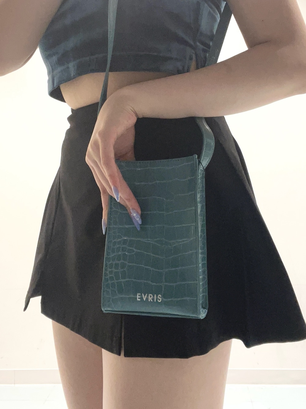 ブルー系のTシャツ/カットソー、ブラック系のスカート、ブラック系のサンダルを着用したレディースの夏コーディネートの6枚目の写真