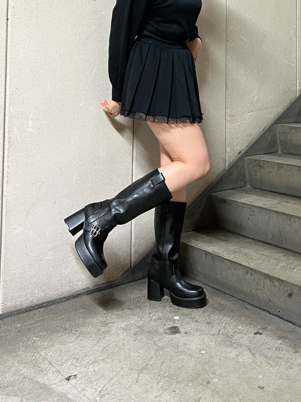 ブラック系のスウェット、ブラック系のショルダーバッグ、ブラック系のスカートを着用したレディースの春コーディネートの8枚目の写真