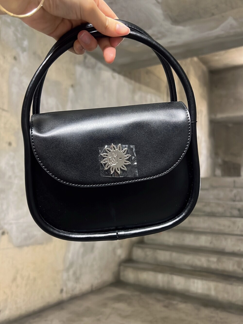 ブラック系のワンピース、ブラック系のブーツ、ブラック系のハンドバッグを着用したレディースの夏コーディネートの6枚目の写真