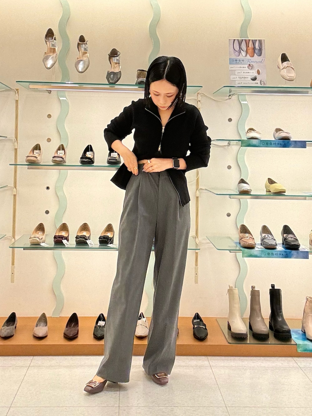 レッド系のパンプス、グレー系のパンツを着用したレディースの秋コーディネートの3枚目の写真