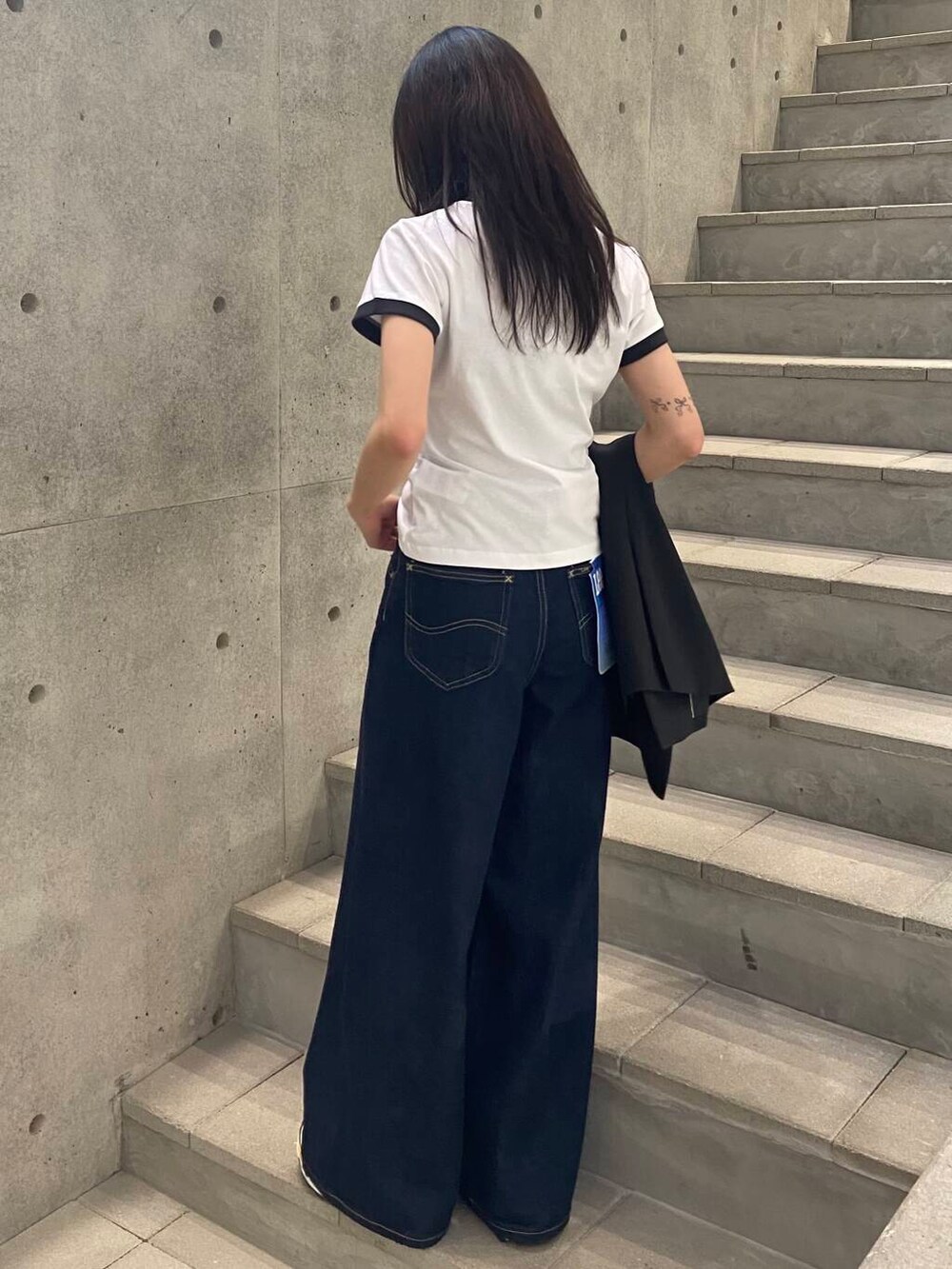 ブラック系のその他アウター、ブルー系のデニムパンツ、ホワイト系のTシャツ/カットソーを着用したレディースの春コーディネートの4枚目の写真