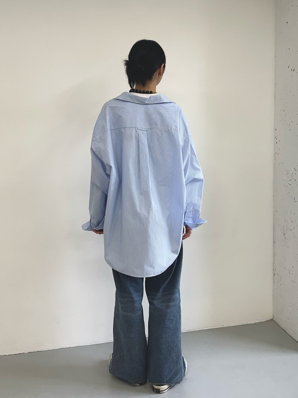 ブルー系のシャツ/ブラウス、ブラック系のスニーカー、ホワイト系のTシャツ/カットソーを着用したレディースの夏コーディネートの2枚目の写真