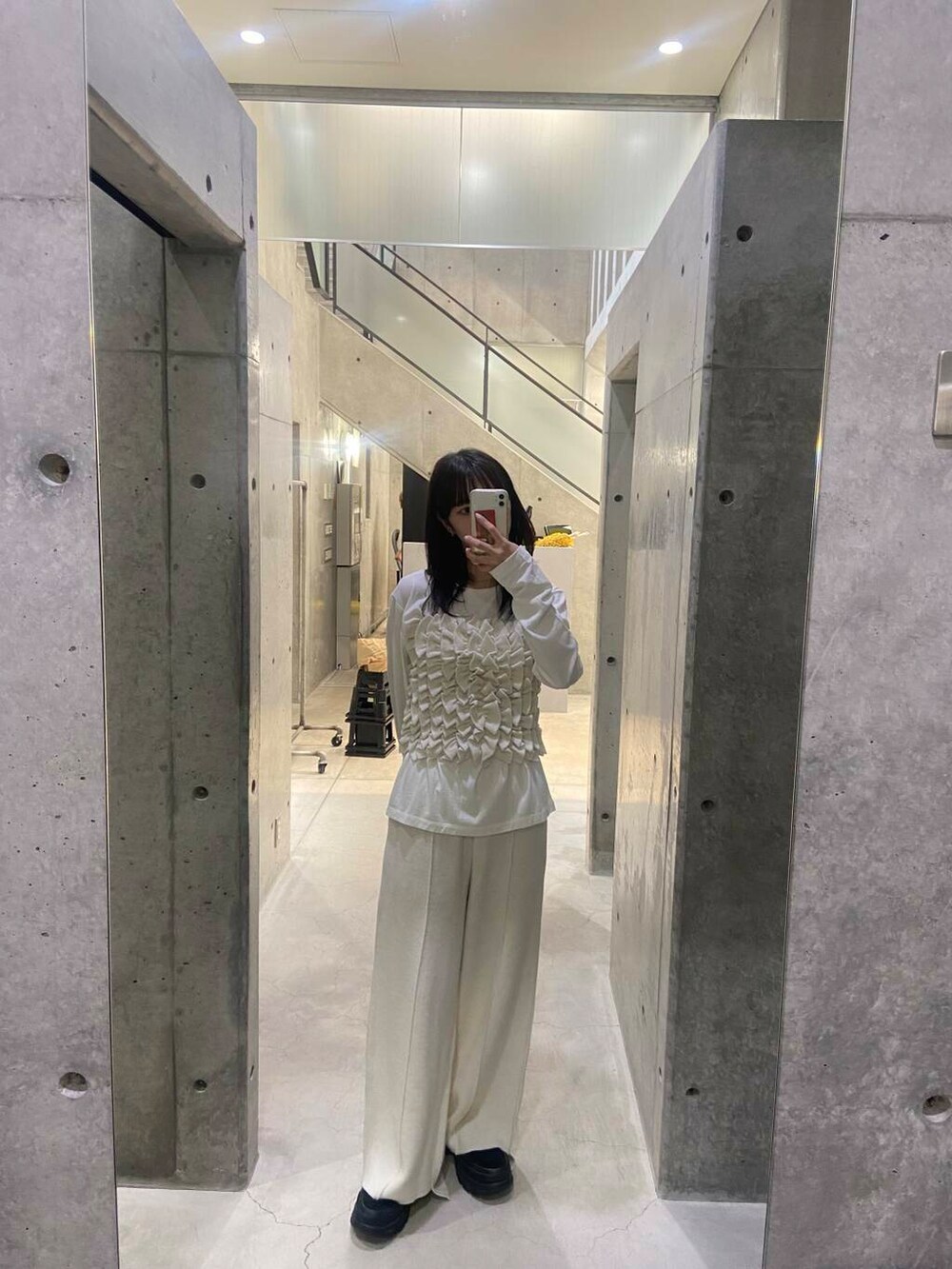 ブラック系のハンドバッグ、ホワイト系のTシャツ/カットソー、グレー系のテーラードジャケットを着用したレディースの秋コーディネートの7枚目の写真